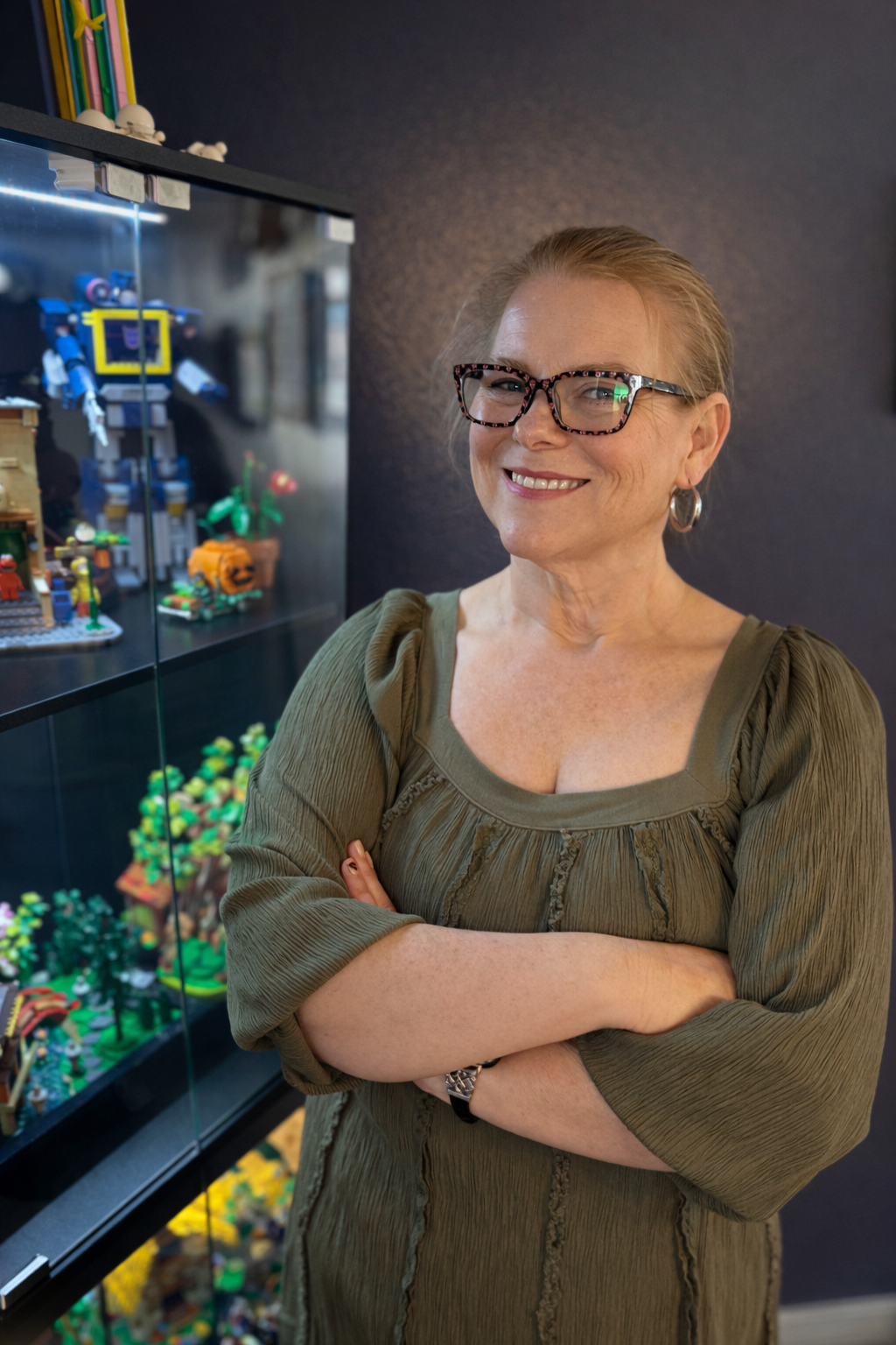 Shannon Stick smiling beside her LEGO collection