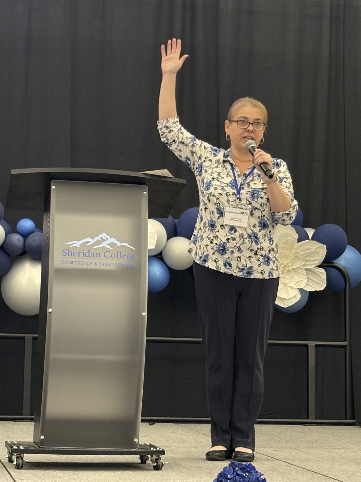 Shannon Stick speaking at a conference with a microphone